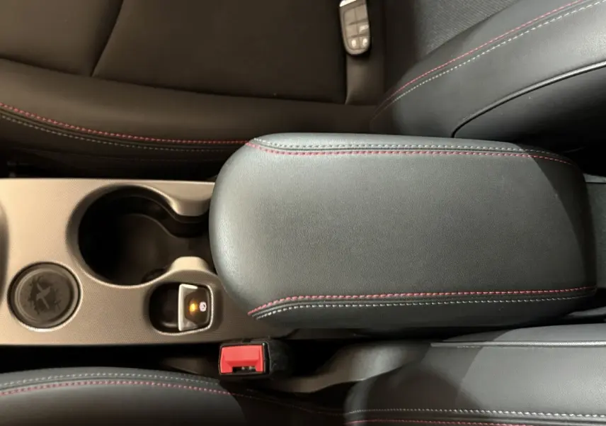 Détail de l'accoudoir central noir avec surpiqûres rouges dans l'habitacle d'une Fiat 500X 2021 Sport.