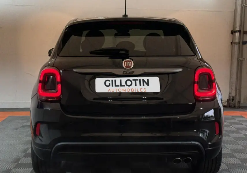 Vue arrière d'un FIAT 500X noir avec feux arrière LED et double sortie d'échappement visible en intérieur.