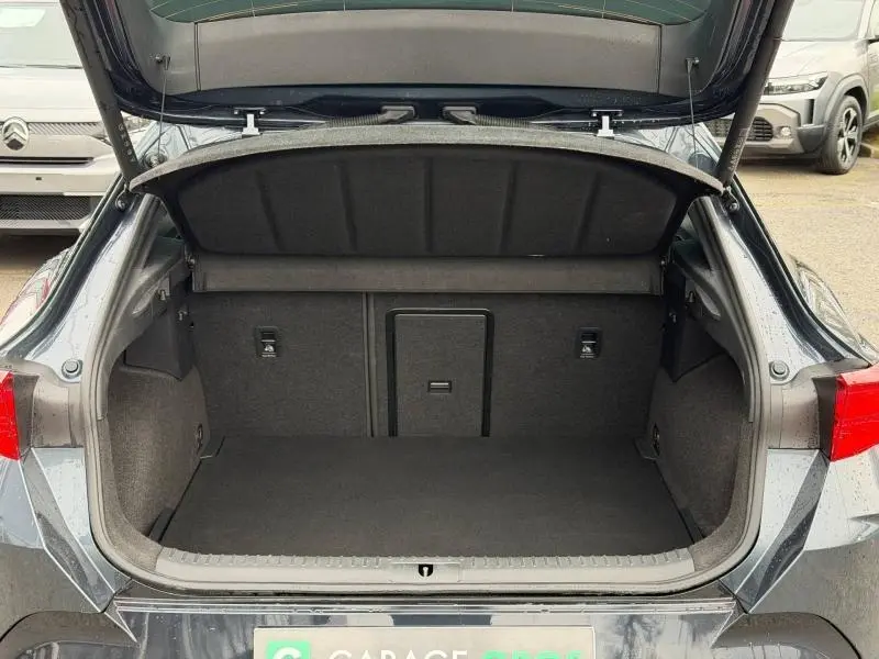 Coffre ouvert vu de l'arrière d'une CUPRA Formentor 1.5 eTSI Hybrid gris graphène personnalisé, montrant l'espace de chargement vide.
