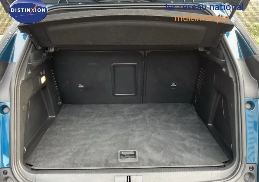Coffre ouvert vu de l'arrière d'un Peugeot 3008 bleu Célèbes Métal, montrant un espace de chargement propre et spacieux.