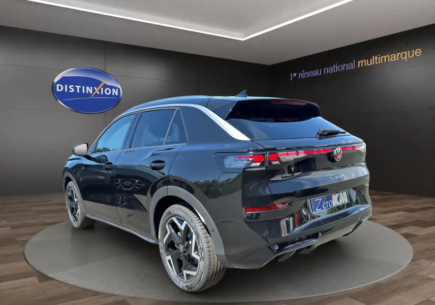 Volkswagen T-Roc noir ébène vu en 3/4 arrière droit, avec attelage et jantes alliage bicolores.