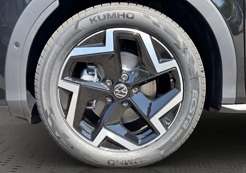 Gros plan sur la roue avant droite noire et argentée du Volkswagen T-Roc 2026 noir ébène avec jante en alliage et pneu Kumho.