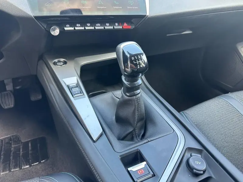 Vue rapprochée de la console centrale de la Peugeot 308 2024 avec levier de vitesse manuel et bouton Drive Mode.