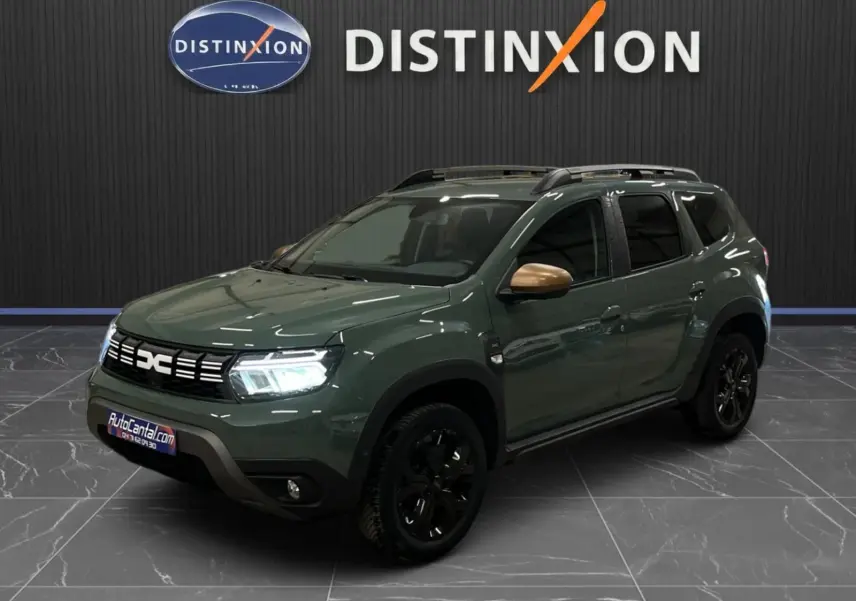 Dacia Duster 2024 kaki lichen en 3/4 avant droit, avec jantes noires et coques de rétroviseurs bronze.