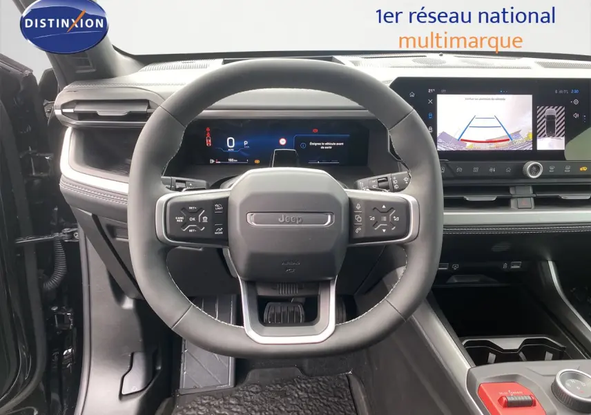 Vue intérieure centrée sur le volant du Jeep Compass noir Vulcano, avec tableau de bord numérique et écran tactile affichant la caméra de recul.