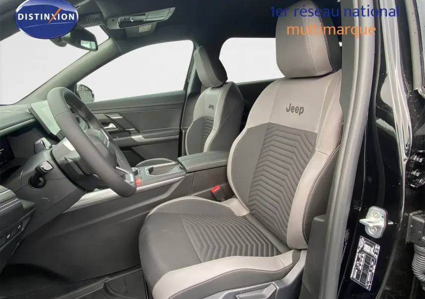 Vue intérieure côté conducteur du Jeep Compass 2026 noir Vulcano, sièges bi-matière avec logo Jeep brodé.