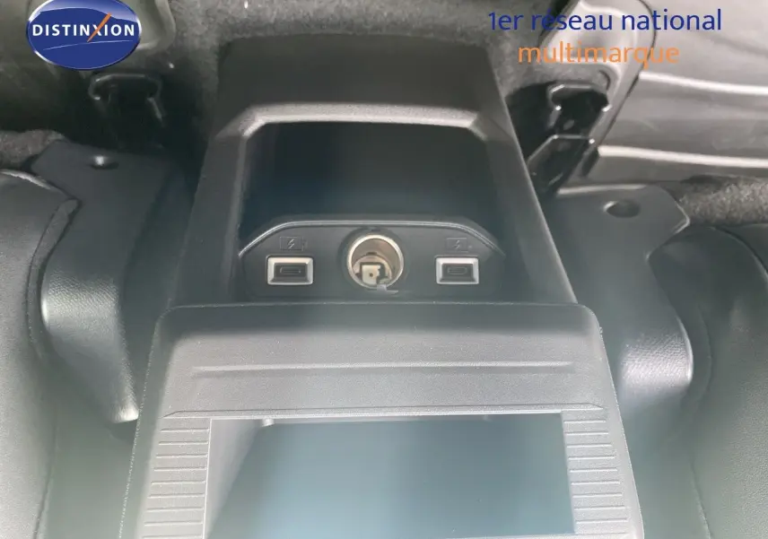 Prise USB et allume-cigare dans le coffre du Jeep Compass noir Vulcano, vue en plongée centrée sur les connectiques.