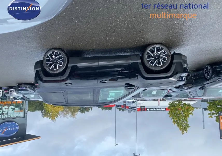 Jeep Compass noir Vulcano métal vu de profil côté gauche sur un parking extérieur avec plusieurs autres véhicules.