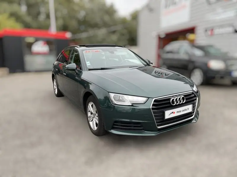 Audi A4 Avant vert vue 3/4 avant droit, avec calandre chromée et phares LED distinctifs.