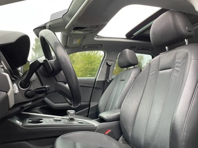 Intérieur de l'Audi A4 Avant 40 TFSI 2019, vue côté conducteur, sièges cuir Milano noir et toit ouvrant panoramique.