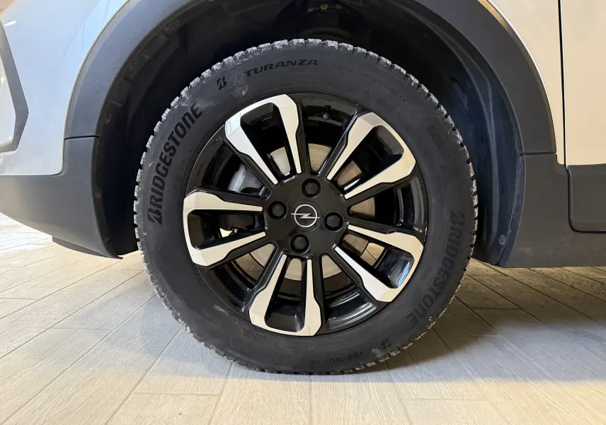 Gros plan sur la roue avant droite gris clair de l’Opel Crossland 2023 avec jante noire et argentée distinctive.