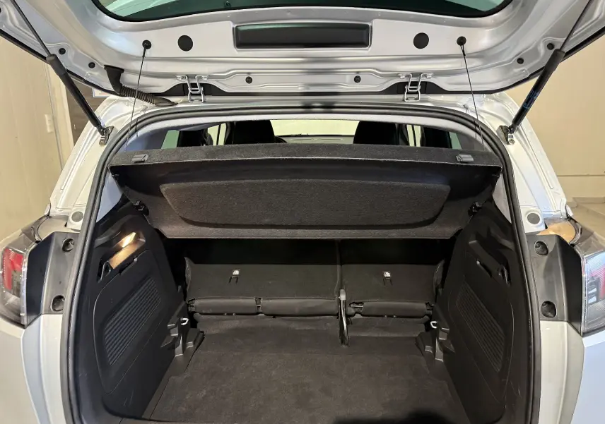 Coffre ouvert vu de l'arrière d'un Opel Crossland gris 2023, montrant l'espace de chargement et la tablette cache-bagages relevée.