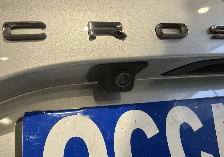 Gros plan sur le coffre arrière gris d’un Opel Crossland 2023 avec caméra de recul intégrée sous le logo.