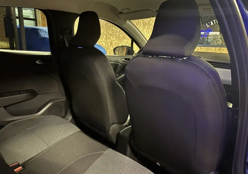 Vue intérieure arrière de la Renault Clio 2024 bleu iron, montrant les sièges avant et arrière en tissu gris noir.