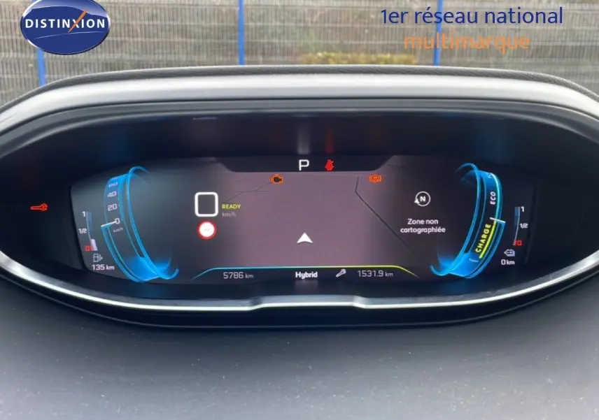 Vue rapprochée du tableau de bord numérique du Peugeot 3008 bleu, affichant les informations hybrides et la navigation.