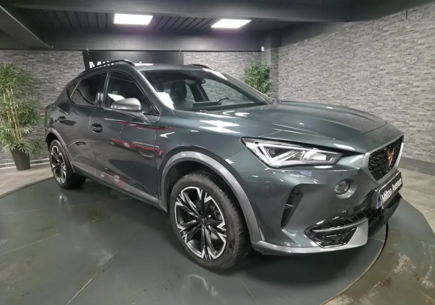 Vue 3/4 avant droite d'un CUPRA Formentor gris Caiman avec jantes alliage 18'' et toit panoramique noir.