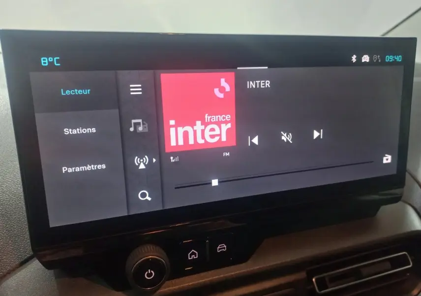 Vue rapprochée de l’écran tactile central du Citroën Berlingo XL blanc, affichant la radio France Inter.