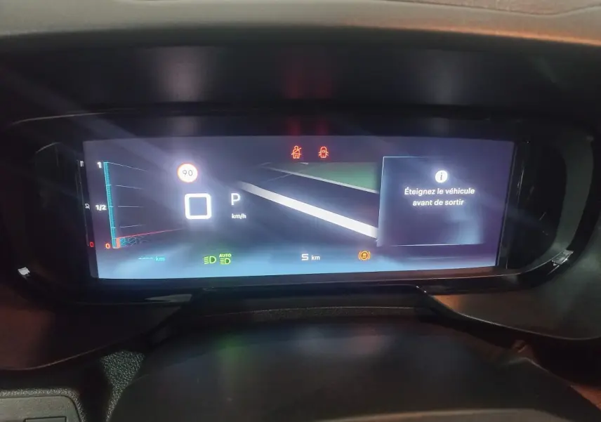 Vue rapprochée du tableau de bord numérique du Citroën Berlingo blanc 2025, affichant la vitesse et alertes.