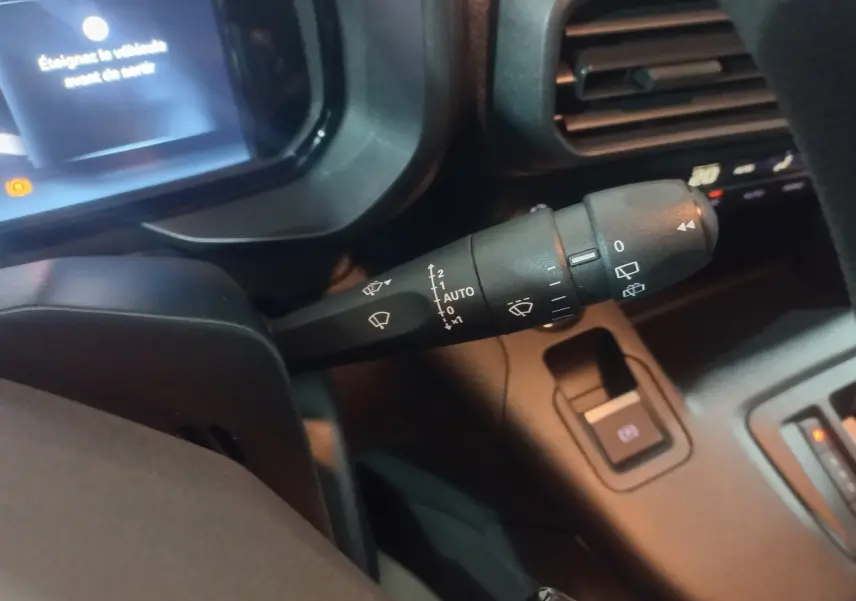 Gros plan sur la commande des essuie-glaces du Citroën Berlingo XL 2025, intérieur noir avec écran digital en arrière-plan.