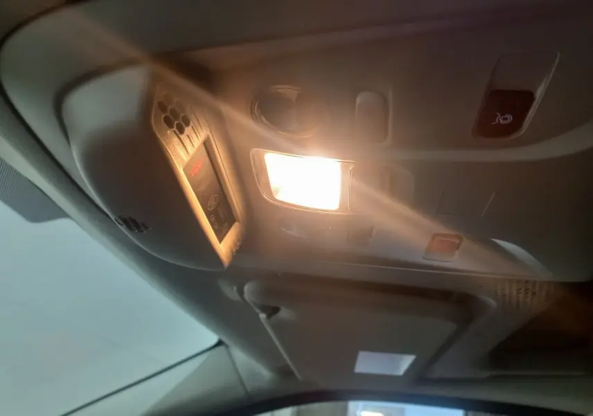 Plafonnier intérieur allumé avec commandes et détecteur dans un Citroën Berlingo XL blanc, vue de l'habitacle avant.