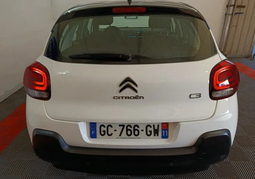 Vue arrière d'une Citroën C3 blanche 2021 avec feux arrière LED et pare-chocs noir mat dans un garage.
