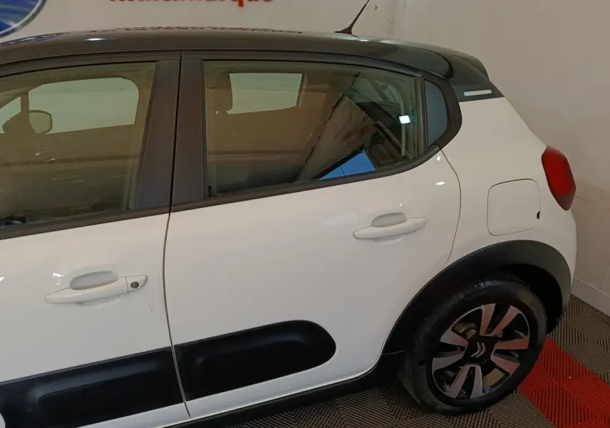 Vue côté droit arrière d'une Citroën C3 blanche avec protections latérales noires et jantes stylisées.
