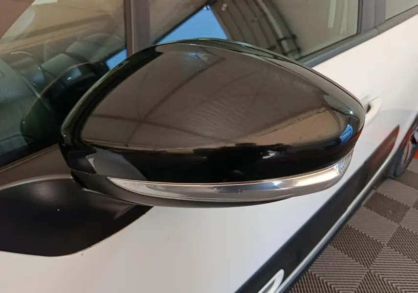 Rétroviseur extérieur noir côté gauche d'une Citroën C3 blanche vue en gros plan sur porte avant.