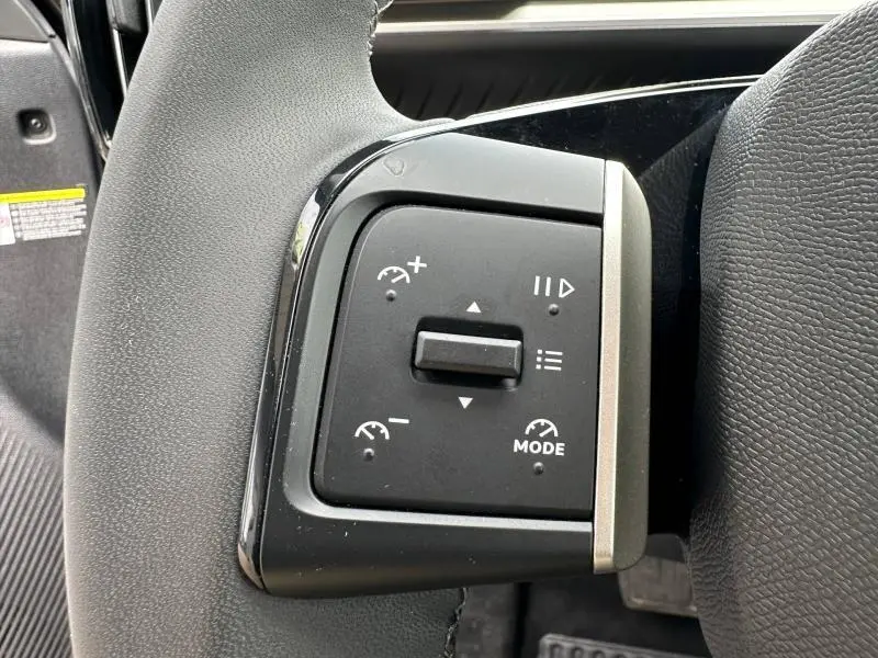 Gros plan sur les commandes de régulateur de vitesse du volant noir de la Citroën C3 électrique 2025.