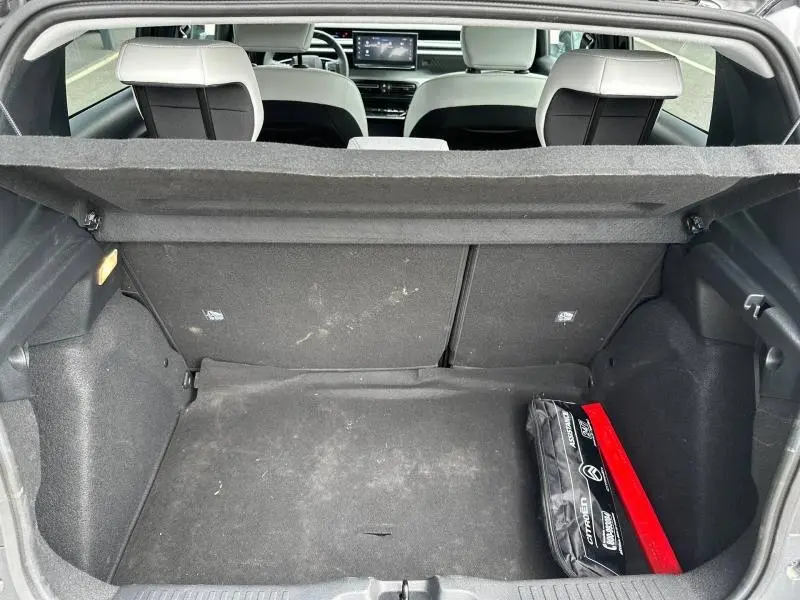 Coffre ouvert d'une Citroën C3 électrique 2025 noir Perla Nera, vue arrière montrant l'intérieur et un kit de secours.