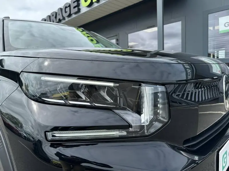 Gros plan sur le phare avant gauche noir Perla Nera de la Citroën C3 électrique 2025, soulignant son design moderne.