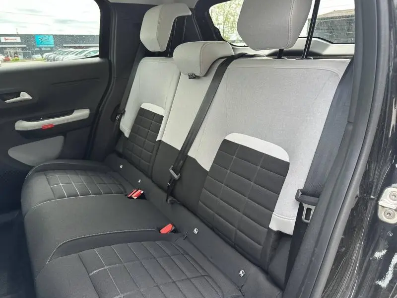 Vue intérieure côté droit des sièges arrière bi-ton gris clair et noir de la Citroën C3 électrique 2025 Noir Perla Nera.