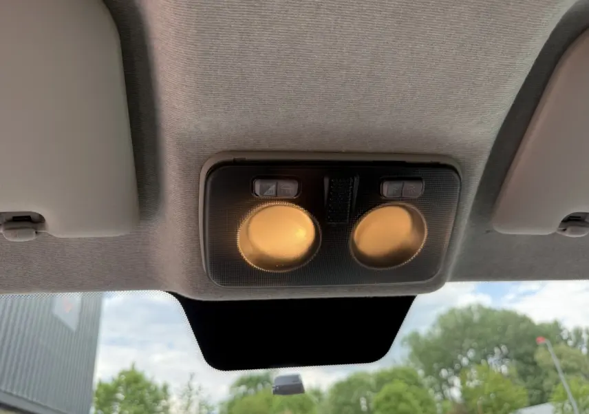 Plafonnier intérieur allumé vu de dessous dans un Peugeot Boxer Fourgon blanc, 3/4 avant, extérieur flou visible.