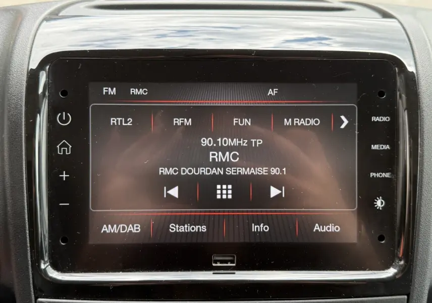 Écran tactile central du tableau de bord du Peugeot Boxer Fourgon blanc, affichant la radio FM RMC.