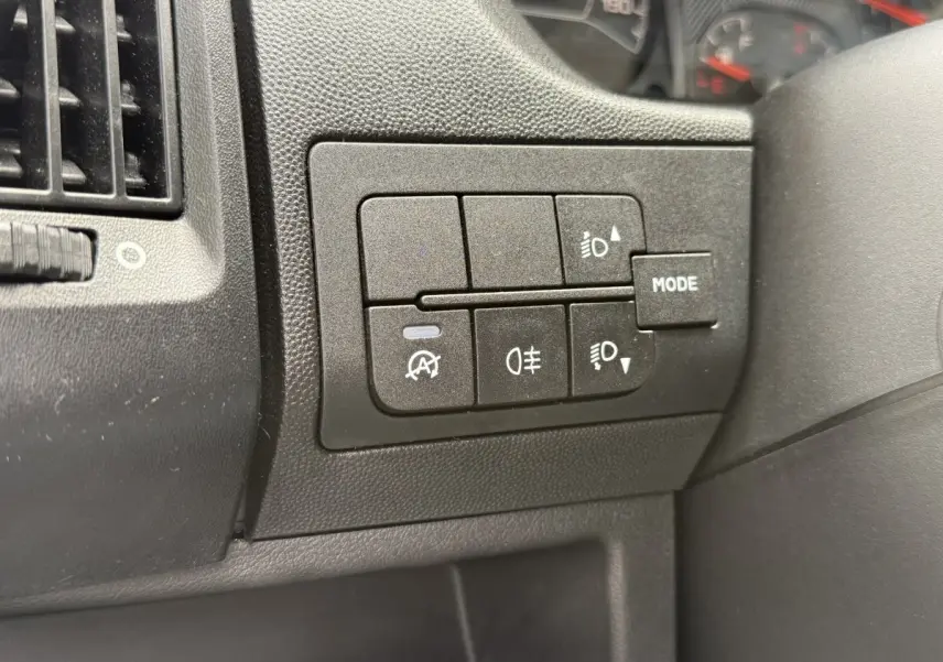 Gros plan sur les commandes d'éclairage et mode du tableau de bord du Peugeot Boxer Fourgon blanc, version 2023.