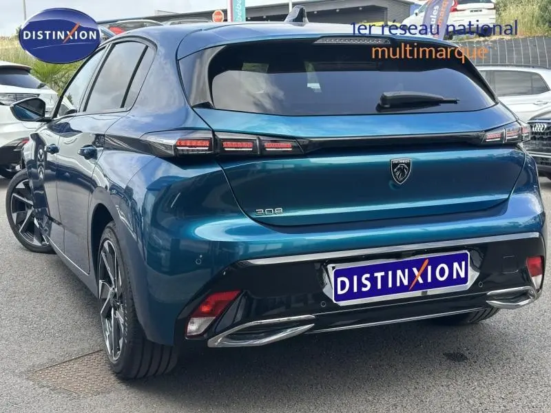 Vue 3/4 arrière droite d'une Peugeot 308 2024 Bleu Obsession avec feux arrière LED et jantes alliage distinctives.
