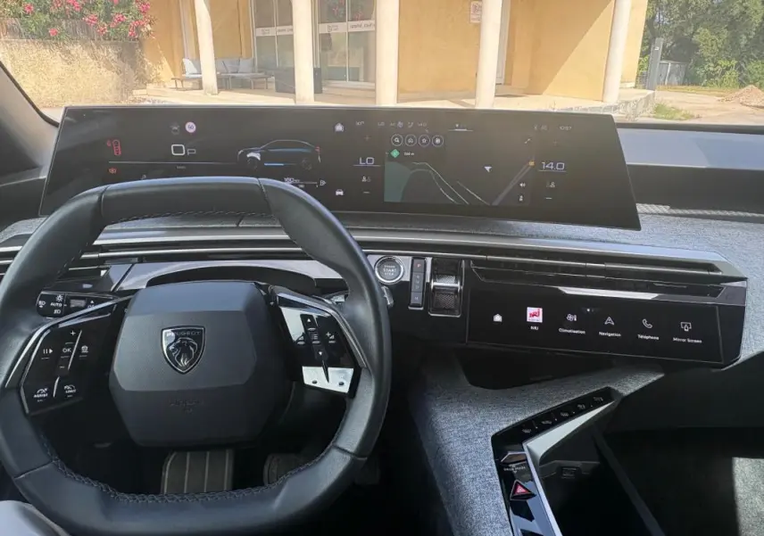 Vue intérieure du tableau de bord du Peugeot 3008 Hybrid 136 e-DCS6 Allure 2025, avec volant compact et double écran numérique.