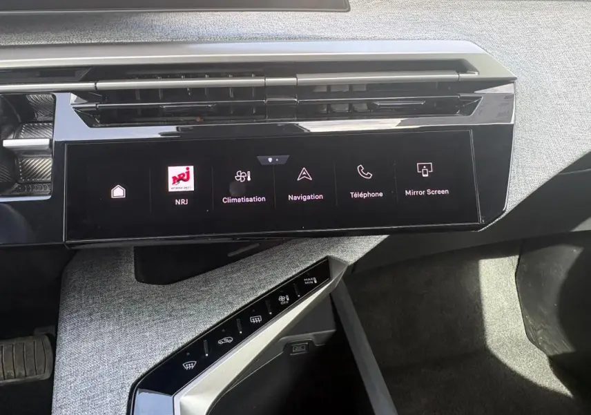 Vue rapprochée de la console centrale du Peugeot 3008 Hybrid noir, avec écran tactile et commandes climatisation.