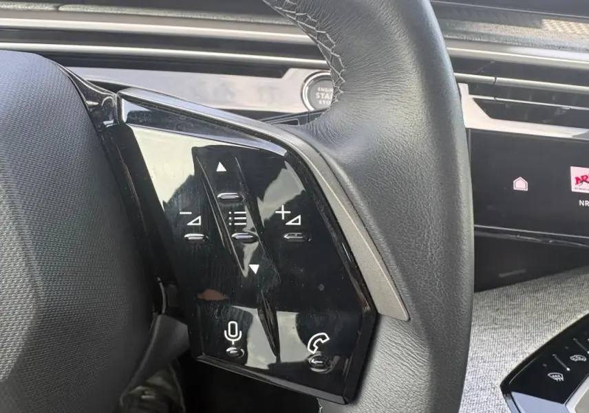 Gros plan sur le volant noir du Peugeot 3008 Hybrid 136 e-DCS6 Allure avec commandes tactiles intégrées.