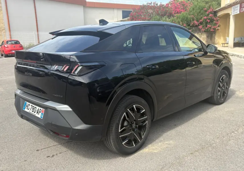 Vue 3/4 arrière droite du Peugeot 3008 Hybrid noir 2025 avec jantes alliage 19 pouces et feux arrière LED distinctifs.