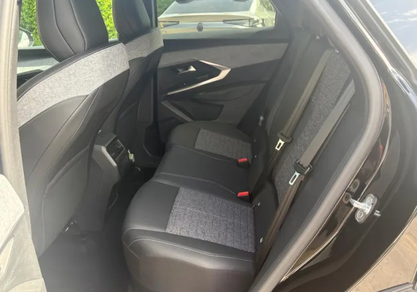 Vue intérieure côté droit des sièges arrière en tissu et cuir gris et noir du Peugeot 3008 Hybrid 136 e-DCS6 Allure 2025 noir.