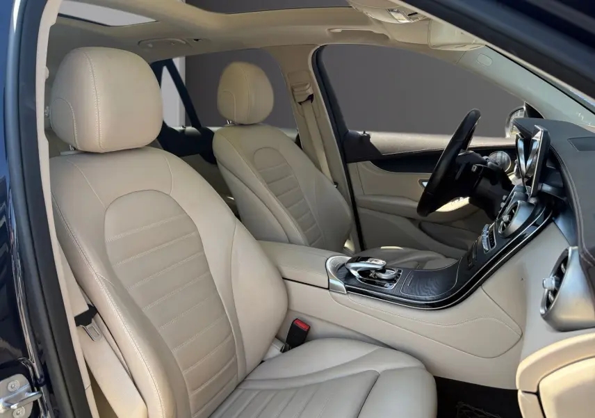 Vue intérieure côté gauche du Mercedes GLC 350 E Hybrid Fascination 2017, sièges cuir beige et tableau de bord noir.