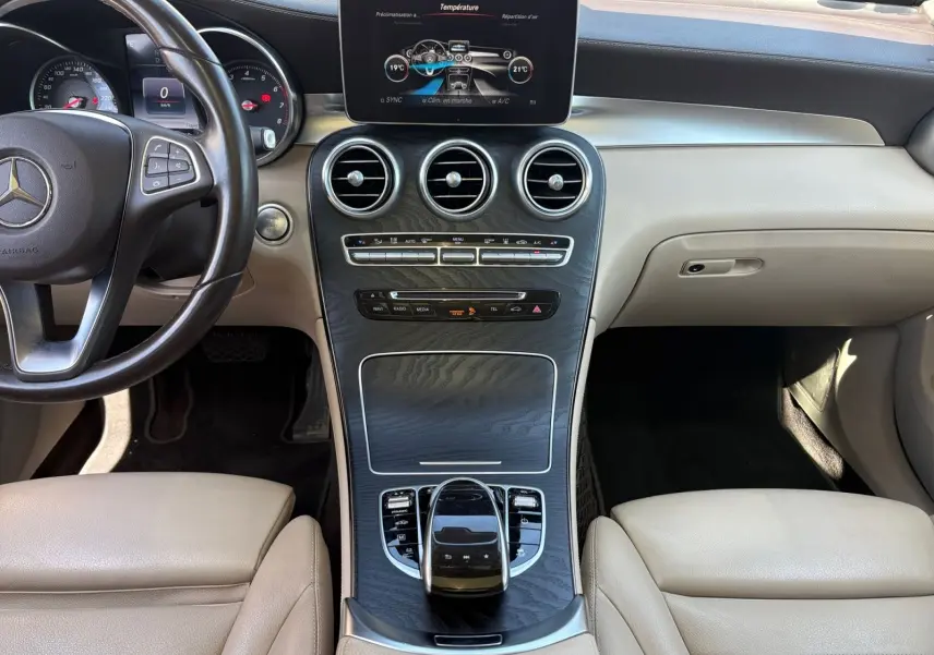 Vue intérieure centrée sur la console centrale et le volant cuir noir du Mercedes GLC 350 E Hybrid Fascination 2017.