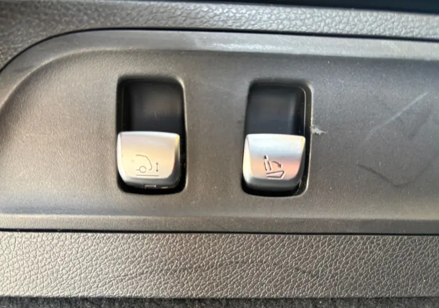 Boutons de commande du hayon électrique et de l'inclinaison des sièges dans l'habitacle d'un Mercedes GLC 350 E Hybride.