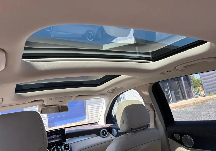 Vue intérieure du toit ouvrant panoramique et tableau de bord clair d'une Mercedes GLC 350 E Hybrid Fascination 2017.