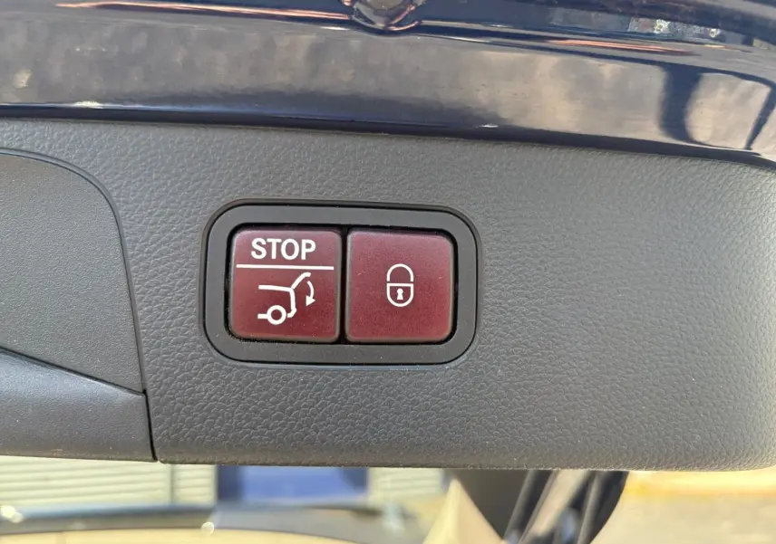Gros plan sur les boutons de hayon électrique et verrouillage, intérieur d'un Mercedes GLC 350 E Hybrid bleu 2017.
