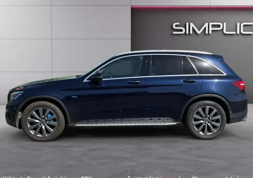 Vue de profil côté gauche d'un Mercedes GLC 350 E Hybrid Fascination bleu avec jantes alliage 19 pouces.