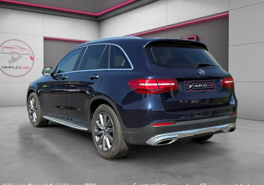 Vue 3/4 arrière droite d'un Mercedes GLC 350 E Hybrid Fascination bleu avec jantes alliage 19 pouces et double sortie d'échappement.