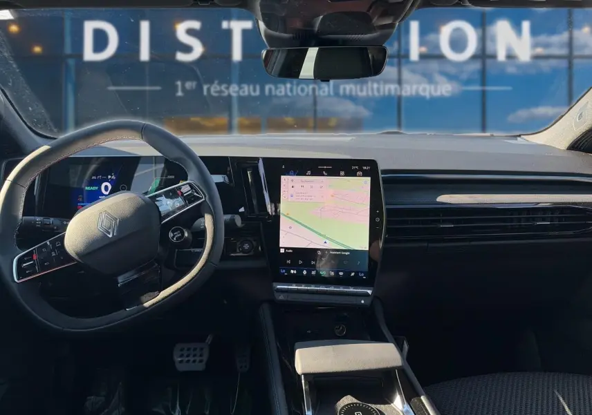 Vue intérieure avant du Renault Austral noir 2026, tableau de bord moderne avec écran tactile central et volant multifonction.