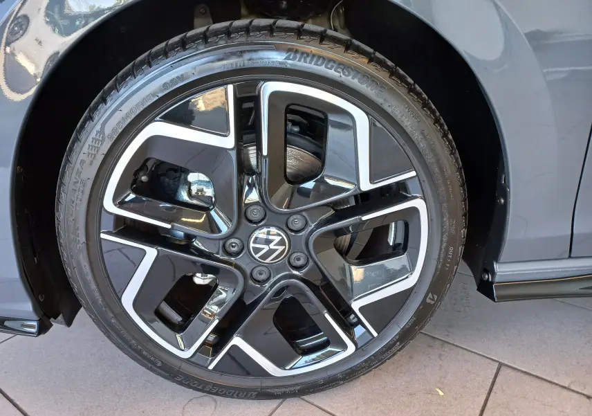 Gros plan sur la jante noire et argentée de la Volkswagen Golf 1.5 eTSI R-Line Edition gris dauphin côté gauche.