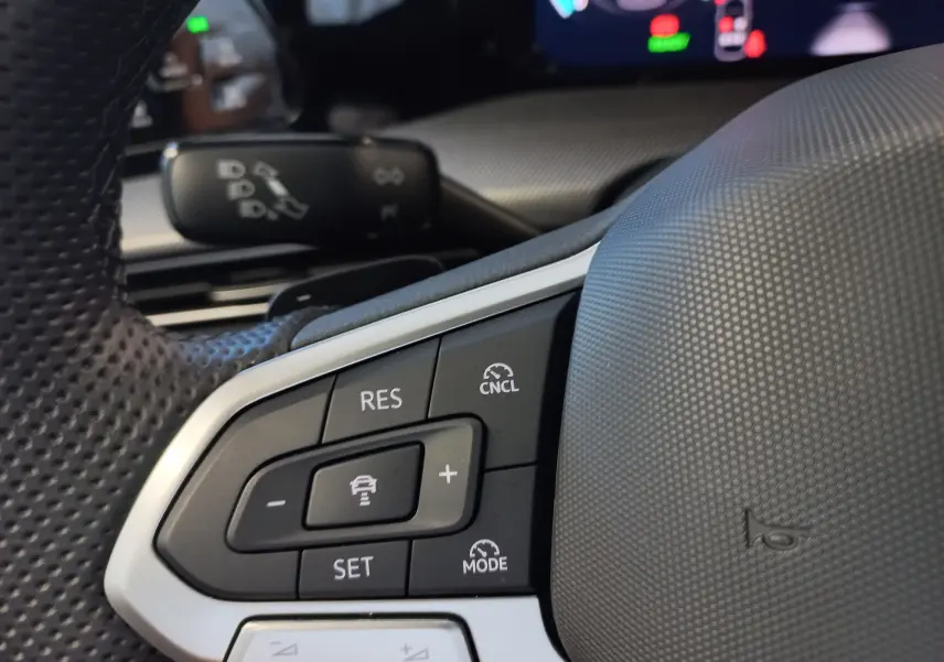 Gros plan sur les commandes du régulateur de vitesse au volant d'une Volkswagen Golf 2025, finition R-Line.